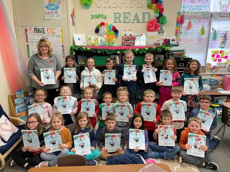 Julie Prantera with a class of students, each holding a copy of Tommy Tablet at Niagara Falls.